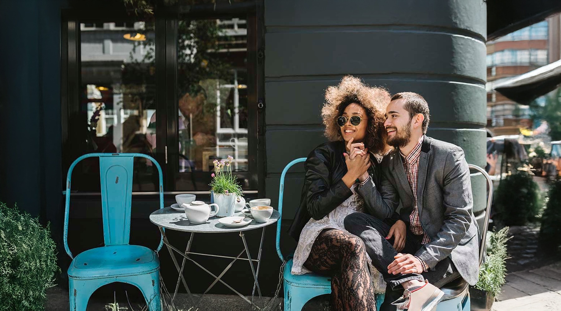 a couple sitting outside of a cafe